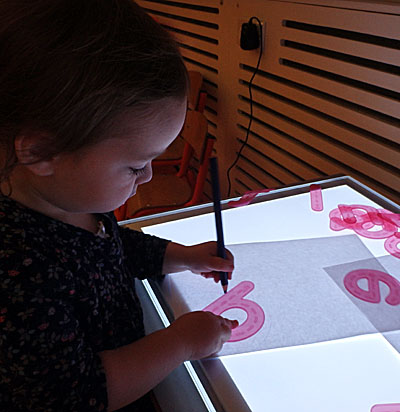 child at minihome nursery traces around la letter